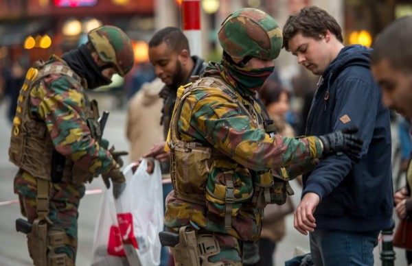 Policemen search passengers at the entrance of the De Brouckere metro station, on March 24, 2016 in Brussels, two days after a triple bomb attack, which responsibility was claimed by the Islamic State group, hit Brussels' airport and the Maelbeek - Maalbeek subway station, killing 31 people and wounding 300 others.A grieving Belgium hunted two fugitive suspects after bombings that struck at the very heart of Europe, as security authorities faced mounting criticism over the country's worst-ever attacks. / AFP PHOTO / PHILIPPE HUGUEN