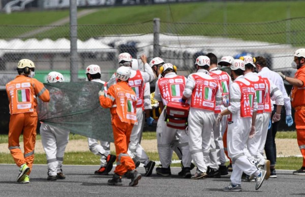 Medical officers evacuate Swiss Moto3 rider Jason Dupasquier in an helicopter after a crash during a qualifying session ahead the Italian Moto GP Grand Prix at the Mugello race track in Scarperia e San Piero on May 29, 2021. - Swiss Moto3 rider Jason Dupasquier was being taken to hospital after a three-bike crash that halted qualifying for the Italian motorcycling Grand Prix at Mugello on May 29, 2021. Organisers said the stricken teenager was being 'taken to hospital in Florence to undergo tests'. Japanese rider Ayumu Sasaki and Spaniard Jeremy Alcoba were the others involved in the accident which delayed the MotoGP fourth practice with organisers reporting both were 'fine'. (Photo by Tiziana FABI / AFP)