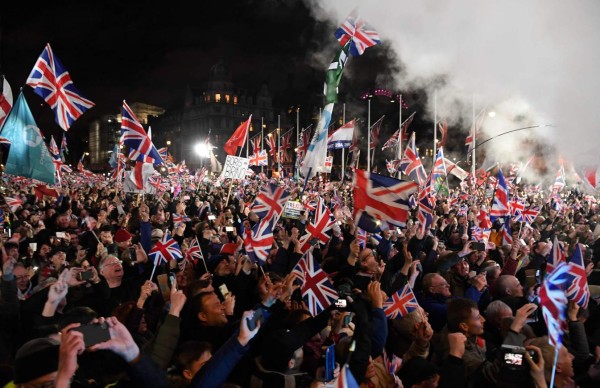 Brexit supporters wave Union flags as the time reaches 11 O'Clock, in Parliament Square, venue for the Leave Means Leave Brexit Celebration in central London on January 31, 2020, the day that the UK formally leaves the European Union. - Brexit supporters gathered outside parliament on Friday to cheer Britain's departure from the European Union following three years of epic political drama -- but for others there were only tears. After 47 years in the European fold, the country leaves the EU at 11:00pm (2300 GMT) on Friday, with a handful of the most enthusiastic supporters gathering opposite the Houses of Parliament 12 hours before the final countdown. (Photo by DANIEL LEAL-OLIVAS / AFP)