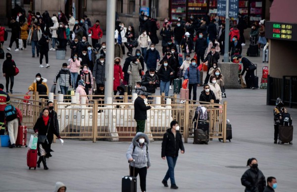 Passengers wearing facemasks arrive from different provinces at the Beijing Railway Station on February 1, 2020. - China faced deepening isolation over its coronavirus epidemic as the death toll soared to 259, with the United States and Australia leading a growing list of nations to impose extraordinary Chinese travel bans. (Photo by NOEL CELIS / AFP)