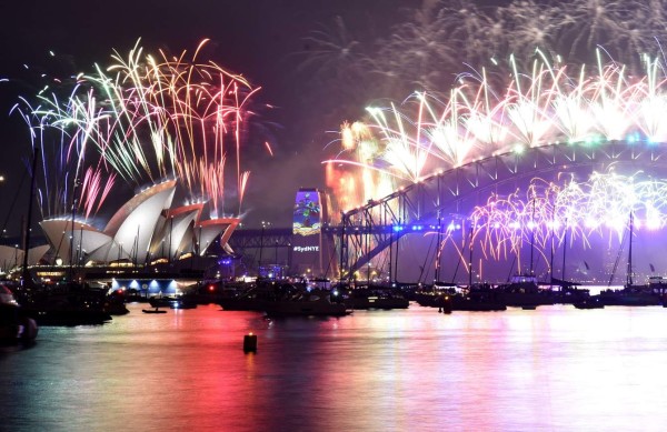 Fuegos artificiales iluminan la Casa de la Ópera y el Puente de la Bahía en Sídney, Australia.
