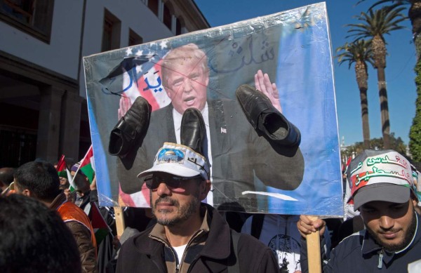 Pro-Palestinian protesters hold a poster of US President Donald Trump covered in shoes in a sign of disrespect during a demonstration in Rabat against his decision to recognise Jerusalem as Israel's capital on December 10, 2017. / AFP PHOTO / FADEL SENNA