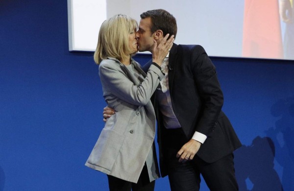 HOR111. Paris (France), 23/04/2017.- French presidential election candidate for the 'En Marche!' (Onwards!) political movement, Emmanuel Macron (R) kisses his wife his wife Brigitte Trogneux (L) after the first round of the French presidential elections in Paris, France, 23 April 2017. Media reports that polling agencies projections place Macron and far-right Front National (FN) party candidate Marine Le-Pen in the lead positions for the vote. France will hold the second round of the presidential elections on 07 May 2017. (Elecciones, Francia) EFE/EPA/YOAN VALAT