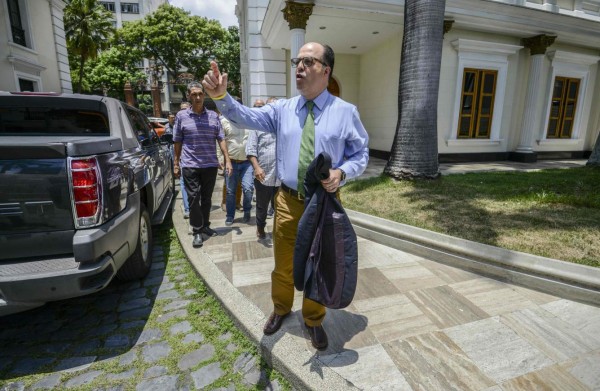 The president of Venezuela's National Assembly Julio Borges walks along a street of Caracas on March 31, 2017. Venezuela's attorney general Luisa Ortega surprisingly broke ranks with President Nicolas Maduro on Friday, condemning recent Supreme Court rulings that consolidated the socialist president's power as a 'rupture of constitutional order.' / AFP PHOTO / JUAN BARRETO