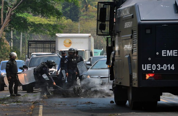 Honduran riot policemen unblock the Tegucigalpa-Olanchoa road, during a protest by locals against the burial of people who died of COVID-19 coronavirus near their communities, on May 4, 2020. (Photo by ORLANDO SIERRA / AFP)