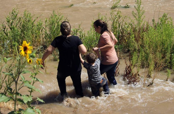Migrants from Brazil cross the Rio Grande in Ciudad Juarez, State of Chihuahua, Mexico, on June 12, 2019, before turning themselves into US Border Patrol agents to claim asylum. (Photo by HERIKA MARTINEZ / AFP)