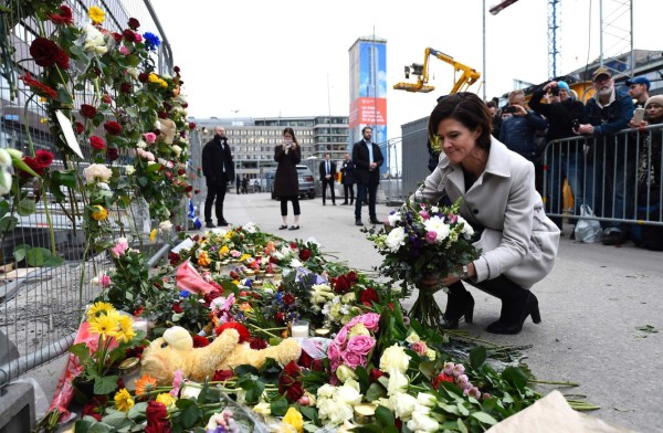 Swedish politician of Moderate party Anna Kinberg Batra lays flowers at a makeshift memorial near the site where a truck slammed into a crowd yesterday outside a busy department store, in central Stockholm, on April 8, 2017. / AFP PHOTO / Jonathan NACKSTRAND