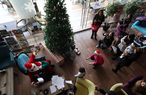 A man dressed as Santa Claus gestures as he plays with children during a Christmas event at the Book Cafe in the northern Iraqi city of Arbil, the capital of the autonomous Kurdistan region, on December 23, 2017. / AFP PHOTO / SAFIN HAMED