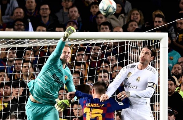 Ter Stegen despejando con el puño derecho ante el acecho de Sergio Ramos. Foto AFP