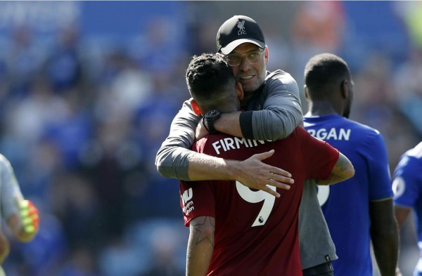 Jürgen Klopp se abraza con el brasileño Roberto Firmino tras ganar al Leicester. Foto AFP