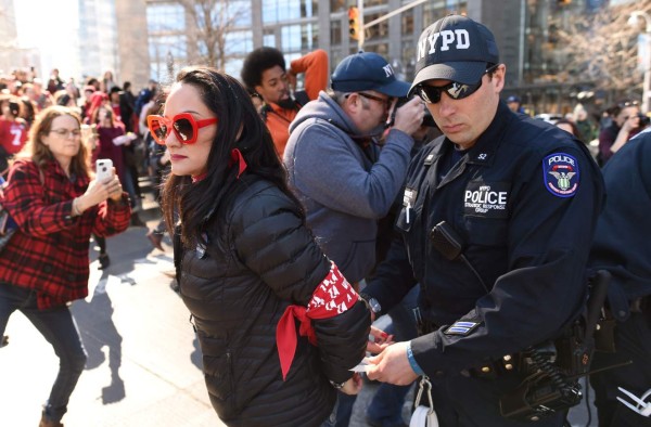 Woman are arrested by the New York City Police Department (NYPD) after sitting down in the street outside the Trump International Hotel and Tower in New York on March 8, 2017 during a #DayWithoutAWoman protest in New York. / AFP PHOTO / TIMOTHY A. CLARY