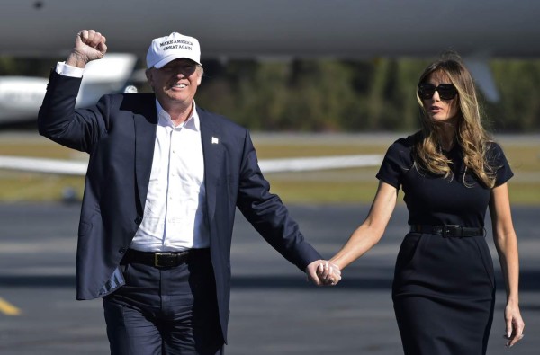 US Republican presidential nominee Donald Trump and his wife Melania make their way to a rally at Wilmington International Airport in Wilmington, North Carolina, on November 5, 2016. / AFP PHOTO / MANDEL NGAN
