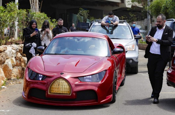 Lebanese-born Palestinian businessman Jihad Mohammad, arrives in the 'Quds Rise', the first ever electric car produced in Lebanon, during an unveiling ceremony in Khaldeh, south of the capital Beirut, on April 24, 2021. The front golden grille represents Al-Aqsa mosque's Dome of the Rock in Jerusalem. - The lebanese-made electric car made its debut in a double first for the Mediterranean country that has never manufactured automobiles and is wracked by economic crisis and power cuts. (Photo by ANWAR AMRO / AFP)