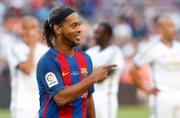 Former Barcelona's Brazilian forward Ronaldinho points his finger after a charity football match between Barcelona Legends vs Manchester United Legends at the Camp Nou stadium in Barcelona on June 30, 2017. / AFP PHOTO / Pau Barrena