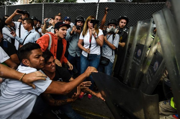 Demonstrators clash with police in an opposition march led by Miranda state Governor Henrique Capriles, as they are blocked from reaching the National Electoral Court in Caracas to demand validation of the signatures to initiate a recall referendum against President Nicolas Maduro, on June 7, 2016. / AFP PHOTO / JUAN BARRETO