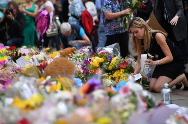 People lay flowers in St Ann's Square after relocating them from Albert Square in Manchester, northwest England on May 24, 2017, placed in tribute to the victims of the May 22 terror attack at the Manchester Arena.Police on Tuesday named Salman Abedi -- reportedly British-born of Libyan descent -- as the suspect behind a suicide bombing that ripped into young fans at an Ariana Grande concert at the Manchester Arena on May 22, as the Islamic State group claimed responsibility for the carnage. / AFP PHOTO / Ben STANSALL