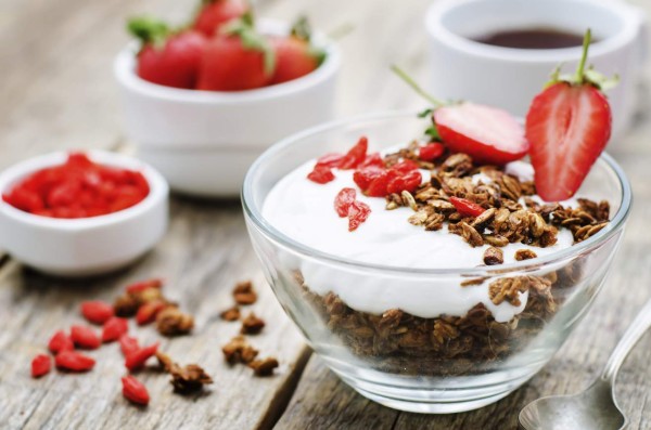 fresh breakfast of granola, yogurt, nuts, goji berries and strawberries. tinting. selective focus