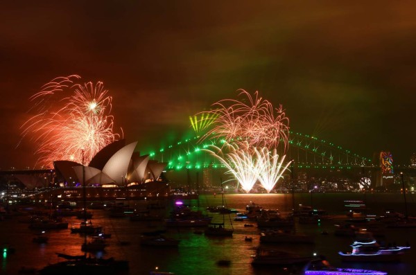 The 'family fireworks', displayed three hours before midnight every year ahead of the main show at midnight, fill the sky over the Opera House and Harbour Bridge in Sydney on New Year's Eve on December 31, 2017. / AFP PHOTO / Saeed KHAN