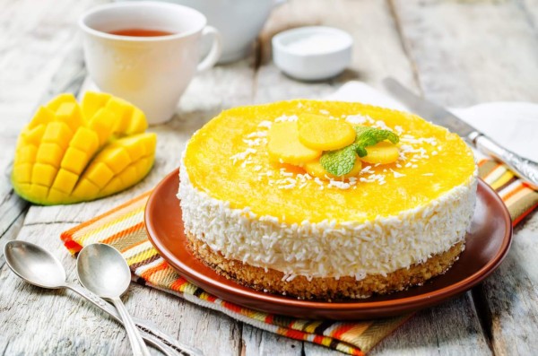 creamy mango mousse cake on a white wood background. toning. selective focus