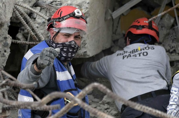 Colombian rescuers search for victims in Pedernales, one of Ecuador's worst-hit towns, on April 18, 2016 two days after a 7.8-magnitude quake hit the country.Rescuers and desperate families clawed through the rubble Monday to pull out survivors of an earthquake that killed 350 people and destroyed towns in a tourist area of Ecuador. / AFP PHOTO / RODRIGO BUENDIA