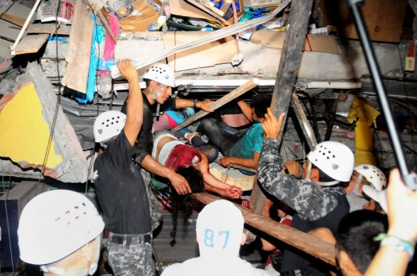 TOPSHOT - Rescue workers work to pull out survivors trapped in a collapsed building after a huge earthquake struck, in the city of Manta early on April 17, 2016. At least 41 people were killed when a powerful 7.8-magnitude earthquake struck Ecuador, destroying buildings and sending terrified residents dashing from their homes, authorities said late on April 16. / AFP PHOTO / API AND AFP PHOTO / Ariel Ochoa