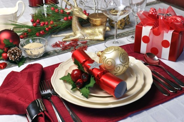 Modern and stylish Christmas dinner table setting including plates, glasses and placemats, bon bons and Christmas decorations Landscape (horizontal) composition.
