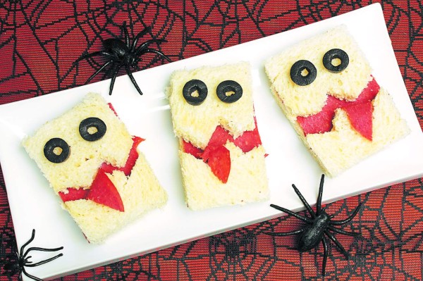 Fun Halloween monster sandwiches on a plate with spiderweb background