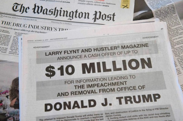 A photo taken on October 15, 2015 in in Washington, DC shows a full-page newspaper advertisement in the Washington Post offering 10 million dollars from Hustler Magazine publisher Larry Flynt for information leading to the impeachment and removal from office of US President Donald Trump. 'I do not expect any of Trump's billionaire cronies to rat him out, but I am confident that there are many people in the know for whom $10 million is a lot of money,' Flynt said in the ad. The porn magazine founder noted that he had used million dollar cash rewards before to elicit information that helped upend the careers of two Republican politicians. / AFP PHOTO / SAUL LOEB