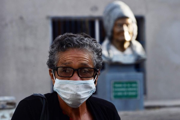 An elderly lady wears a protective face mask, in an attempt to prevent catching the new Coronavirus, COVID-19, in Tegucigalpa, on March 13, 2020. - The Honduran government has suspended classes at schools and universities. (Photo by ORLANDO SIERRA / AFP)