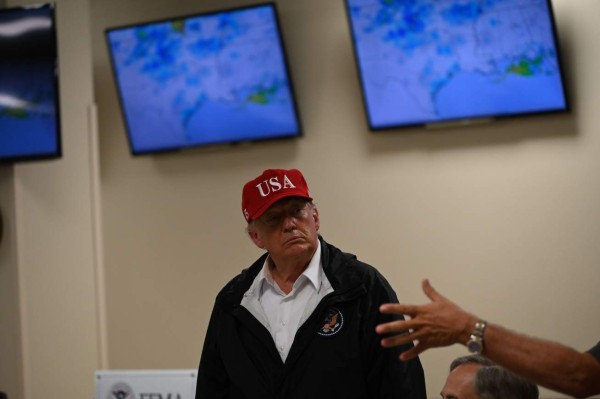 US President Donald Trump, with Texas Governor Greg Abbott (C), arrives at an emergency operation center in Orange, Texas, for a briefing on August 29, 2020. Trump surveyed damage in the area caused by Hurricane Laura. - At least 15 people were killed after Laura slammed into the southern US states of Louisiana and Texas, authorities and local media said on August 28. (Photo by ROBERTO SCHMIDT / AFP)