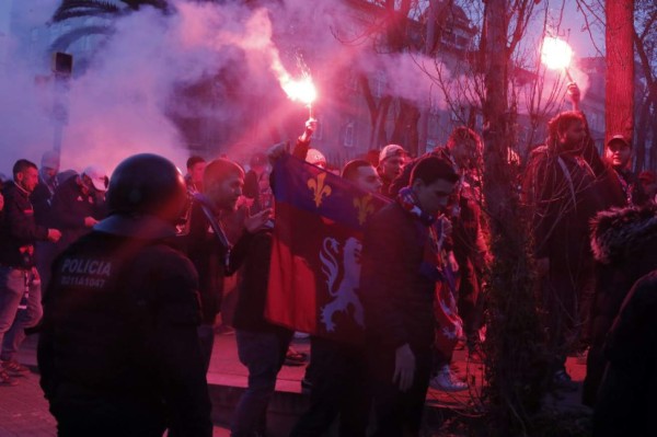 Lyon fans hold flares as they approach the stadium before the UEFA Champions League round of 16, second leg football match between FC Barcelona and Olympique Lyonnais at the Camp Nou stadium in Barcelona on March 13, 2019. (Photo by Pau Barrena / AFP)