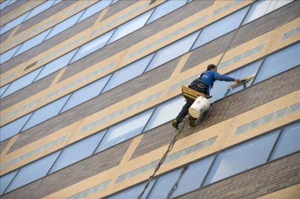 En la imagen, un trabajador limpia las ventanas de un edificio. EFE/Archivo