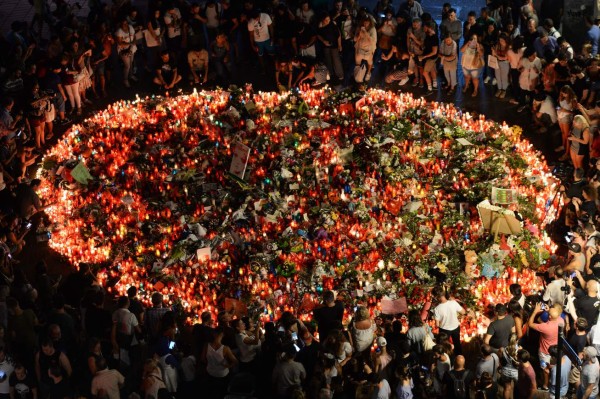 People pay tribute to the victims of the Barcelona attack on Las Ramblas boulevard in Barcelona on August 19, 2017, two days after a van ploughed into the crowd, killing 13 persons and injuring over 100.Drivers have ploughed on August 17, 2017 into pedestrians in two quick-succession, separate attacks in Barcelona and another popular Spanish seaside city, leaving 14 people dead and injuring more than 100 others. / AFP PHOTO / Josep LAGO