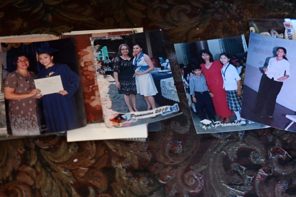 View of pictures Mirna Cruz Lima and her children Jackeline Cristina and Alexis Palomo Lima, victims of a serial killer policeman, in Santa Ana, El Salvador on May 27, 2021. - At least 18 people were found dead at former policeman Hugo Osorio Chavez's home in Chalchuapa, El Salvador. (Photo by STR / AFP)