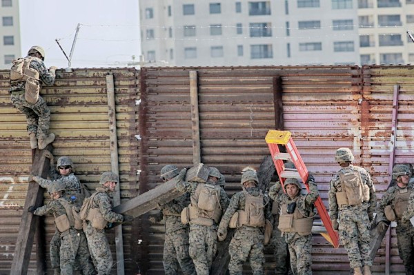 US marines put barbed wire atop fencing along the United States-Mexico border in San Ysidro, California, on November 9, 2018. (Photo by Sandy Huffaker / AFP)