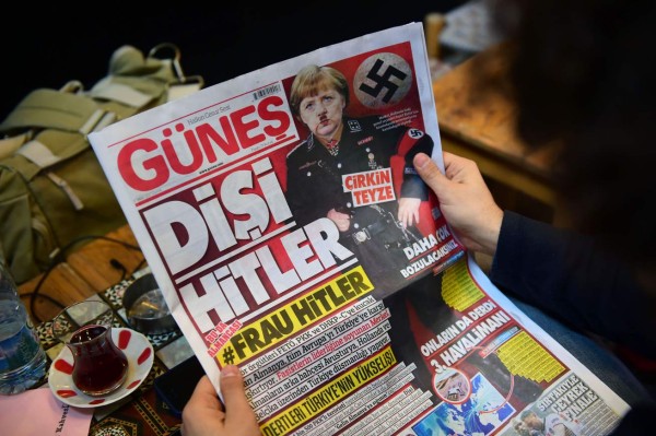 A man reads an issue of Gunes, a Turkish pro-government daily newspaper, with on its front page German Chancellor Angela Merkel depicted in Nazi uniform with a Hitler-style moustache, labelling the German leader 'She Hitler', on March 17, 2017 in Istanbul, Turkey. Right-wing tabloid-style daily Gunes ('Sun') printed the picture along with the words in German: '#Frau Hitler' and called her an 'ugly aunt', amid a bitter war of words between Ankara and Berlin. Turkey and Europe are locked in a bitter spat after Germany and the Netherlands blocked Turkish ministers from holding rallies to campaign for a 'yes' vote in next month's referendum on expanding President Recep Tayyip Erdogan's powers. / AFP PHOTO / YASIN AKGUL