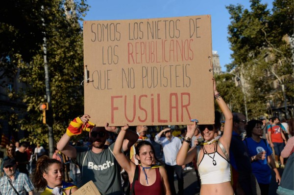 Young people wave a placard reading 'We are the grandsons of the republicans you could not execute' in Barcelona during a demonstration on a general strike day in Catalonia called by Catalan unions on October 3, 2017.Large numbers of Catalans observe a general strike today to condemn police violence at a banned weekend referendum on independence, as Madrid comes under growing international pressure to resolve its worst political crisis in decades. / AFP PHOTO / Josep LAGO