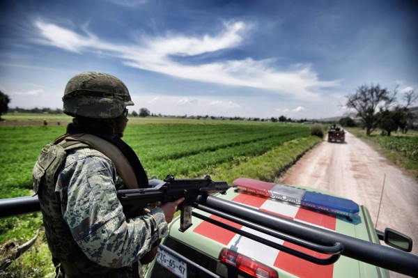 A Mexican army soldier patrols a clandestine fuel siphoning area in Tepeaca, Puebla State, Mexico on May 26, 2017. Violent clashes between troops and suspected oil thieves have left a dozen dead, including several soldiers. / AFP PHOTO / ALFREDO ESTRELLA