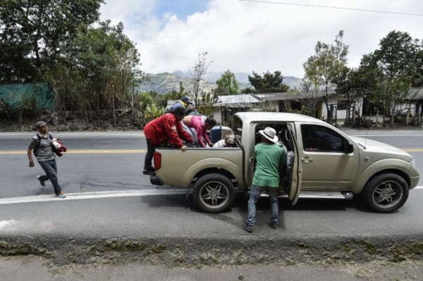 Members of the Mendoza Landinez family along with other Venezuelan migrants, get on a pick-up van on the Pan-American highway, between Pasto and Ipiales on their way to Peru on August 23, 2018.On foot, by bus, on the backs of juddering trucks, like tens of thousands of others they slogged for days along the Pan-American highway through Colombia and Ecuador. Grubby and sleepless, their goal was to reach Peru, a sanctuary of sorts for a desperate Venezuelan family. Exhausted and swept by the endless wash of traffic noise on the highway's shoulder, the Mendoza Landinez family had the additional pressure of a deadline: to enter Peru before new rules required them to produce a passport. / AFP PHOTO / Luis ROBAYO