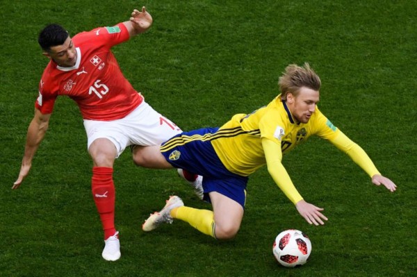 El suizo Blerim Dzemaili (izquierda) disputa el balón con el sueco Emil Forsberg. Foto AFP