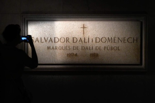 A visitor takes a picture of Salvador Dali's tombstone inside the Teatre-Museu Dali (Theatre-Museum Dali) in Figueras on July 18, 2017 ahead of the exhumation of the artist's remains.The remains of the world-famous surrealist, who is buried in his museum in Figueras, in northeastern Spain, were ordered exhumed after a woman who claims to be his daughter filed a paternity claim. / AFP PHOTO / LLUIS GENE