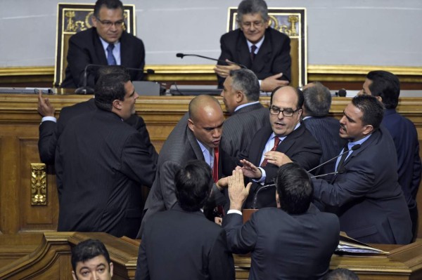 Newly elected opposition deputy Julio Borges (C) and governement deputy Hector Rodriguez (2nd L) argue during the new parliament's swearing-in ceremony in Caracas, on January 5, 2016. Venezuela's President Nicolas Maduro ordered the security forces to ensure the swearing-in of a new opposition-dominated legislature passes off peacefully Tuesday, after calls for rallies raised fears of unrest. AFP PHOTO/JUAN BARRETO