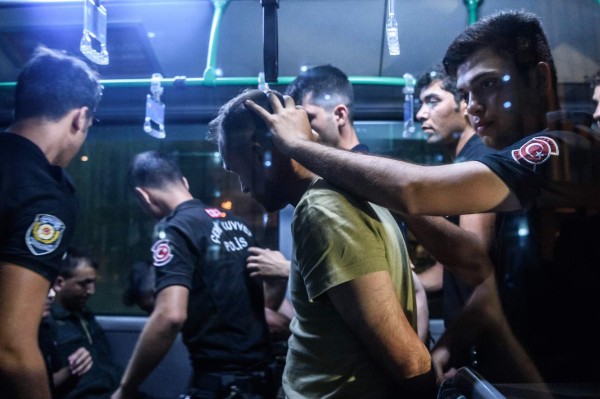 Turkish anti riot police officers detain a Turkish soldier who allegedly took part in a military coup as they are leaving in a bus the courthouse at Bakirkoy district in Istanbul on July 16, 2016. President Recep Tayyip Erdogan battled to regain control over Turkey on July 16, 2016 after a coup that claimed more than 250 lives, bid by discontented soldiers, as signs grew that the most serious challenge to his 13 years of dominant rule was faltering. / AFP PHOTO / OZAN KOSE