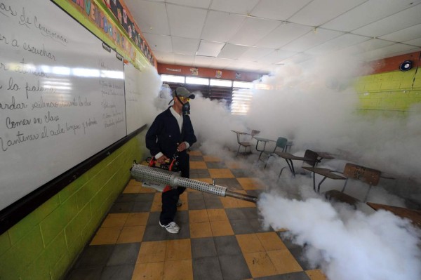 Health ministry personnel fumigate against the Aedes aegypti mosquito, vector of the dengue, Chikungunya and Zika viruses in Tegucigalpa, , on February 1, 2016. Honduran President Juan Orlando Hernandez on Friday declared the country on a preventive state of alert due to the Zika virus which in the last 44 days killed a person and infected some 1000. AFP PHOTO/Orlando SIERRA.