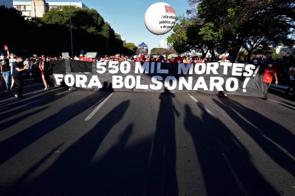 Demonstrators holds a banner reading 550 thousand deaths. Bolsonaro out! during a protest against the government of Brazilian President Jair Bolsonaro at the Esplanede of Ministries in Brasilia, on July 24, 2021. (Photo by EVARISTO SA / AFP)