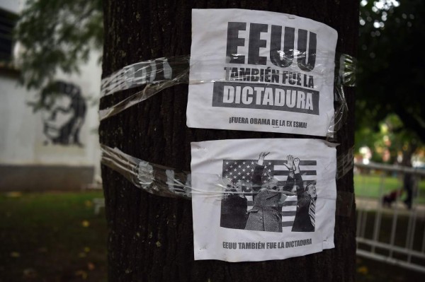 A sign that reads 'The US was also the dictatorship' is stuck to a tree at the former clandestine detention center of the Navy School of Mechanics (ESMA) in Buenos Aires on March 19, 2016. The United States said on March 17 that it would begin declassifying sensitive military and intelligence records linked to Argentina's 'dirty war.' The announcement came days before President Barack Obama's visit to Argentina, which coincides with the 40th anniversary of the right-wing military coup that the US government condoned. AFP PHOTO/EITAN ABRAMOVICH