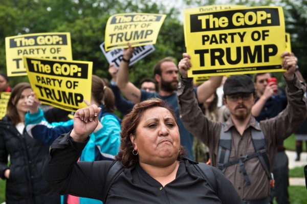 Protesters rally outside during a meeting between Republican US presidential candidate Donald Trump, Senate Majority Leader Senator Mitch McConnell (R-KY) and other Republicans at the National Republican Senatorial Committee May 12, 2016 in Washington, DC. / AFP PHOTO / Brendan Smialowski