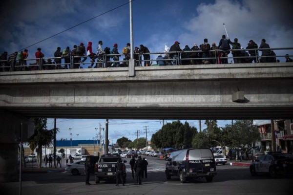 Central American migrants -mostly Hondurans- moving towards the United States in hopes of a better life, gather in El Chaparral, Tijuana, Baja California State, Mexico, on November 22, 2018 to ask US authorities to allow them to apply for asylum. - US President Donald Trump renewed his attacks on the judiciary on Thanksgiving Day Thursday, accusing judges of making the country unsafe as he fanned a bitter row over asylum seekers on the US-Mexico border. (Photo by Pedro PARDO / AFP)