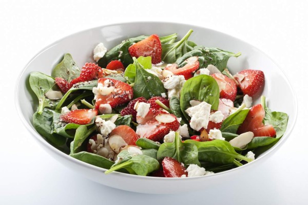'SEVERAL MORE IN THIS SERIES. Fresh salad of baby spinach leaves, sliced strawberries, slivered almonds, feta cheese, and a light dressing. Isolated on white, includes clipping path.'