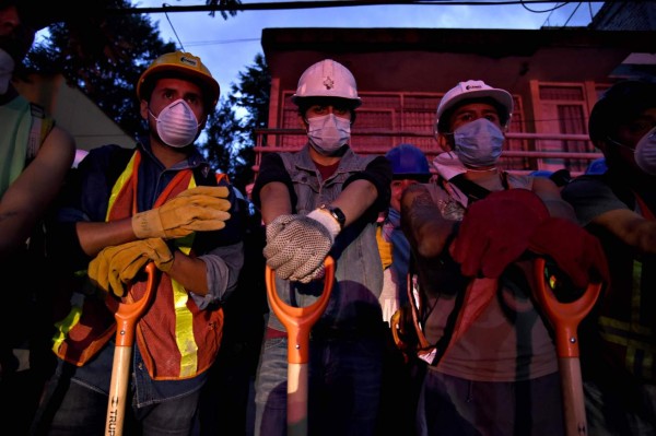 Volunteer rescuers stand by for their turn to arrive to begin taking part in the cleanup of rubble from collapsed buildings in search of survivors, in Mexico City, on September 20, 2017 one day after a powerful 7.1-magnitude quake devastated part of the country.At least 216 people were killed when a powerful 7.1-magnitude earthquake struck Mexico on Tuesday, including 21 children crushed beneath an elementary school that was reduced to rubble. / AFP PHOTO / Alfredo ESTRELLA